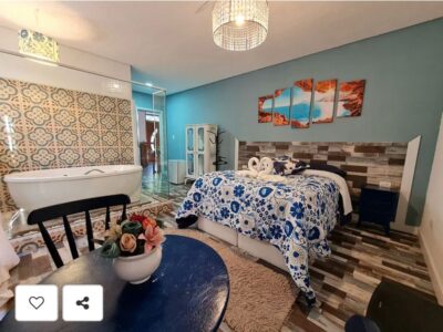 Suíte Grega, com banheira de hidromassagem, lareira elétrica e deck com vista para mata