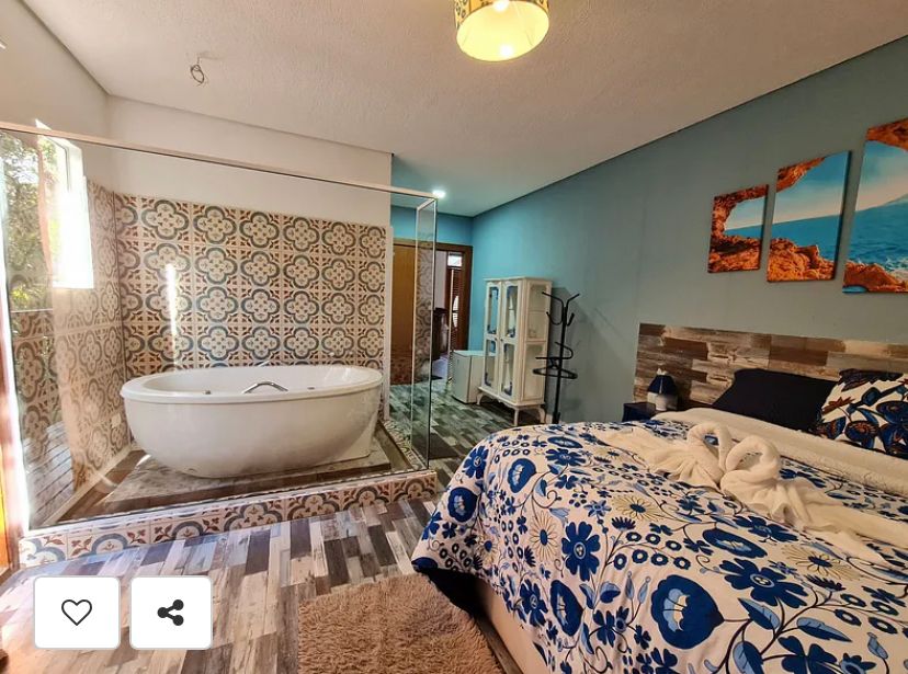 Suíte Grega, com banheira de hidromassagem, lareira elétrica e deck com vista para mata