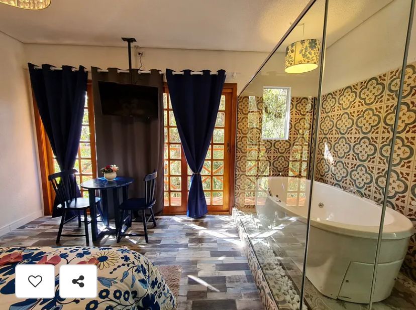 Suíte Grega, com banheira de hidromassagem, lareira elétrica e deck com vista para mata