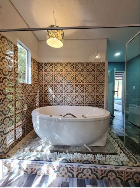 Suíte Grega, com banheira de hidromassagem, lareira elétrica e deck com vista para mata