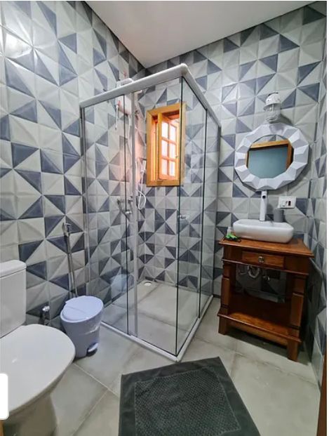 Suíte Grega, com banheira de hidromassagem, lareira elétrica e deck com vista para mata