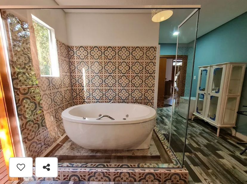 Suíte Grega, com banheira de hidromassagem, lareira elétrica e deck com vista para mata