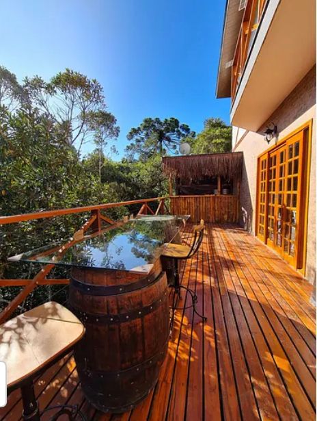 Suíte Grega, com banheira de hidromassagem, lareira elétrica e deck com vista para mata